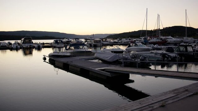 Boats moored on the pier during the sunset with hills in the background