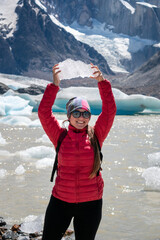 Mujer sosteniendo bloque de hielo en la Laguna Torre, en señal de triunfo por haber llegado allí. El Chalten, Patagonia Argentina