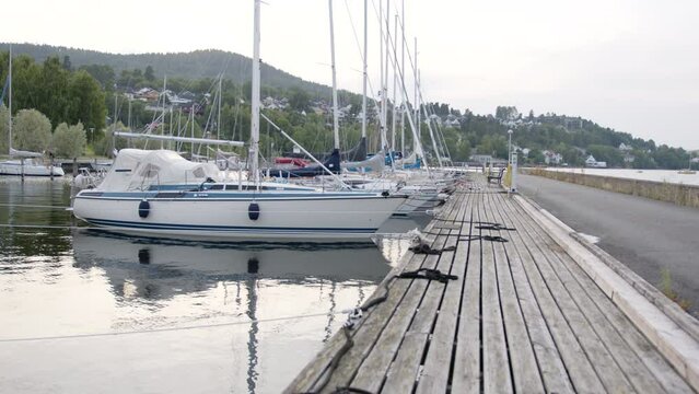 Boats moored on the pier during the daytime with hills in the background