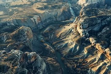 A winding river cuts through a rugged canyon with steep cliffs and rock formations visible from above