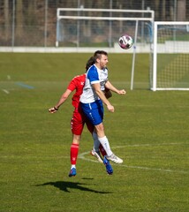 Obraz premium Football players in the motion of jumping, trying to catch the ball in the green field