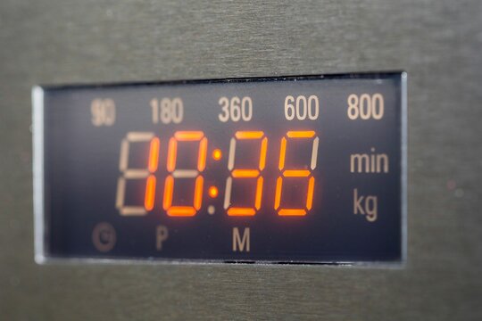 Stainless steel digital microwave oven with the timer displayed on the clock face