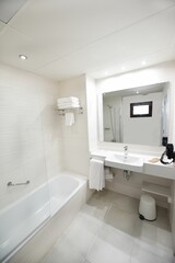 Fototapeta na wymiar Contemporary bathroom featuring a large bathtub, a pedestal sink, and a spacious stand-up shower