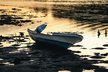 Old boat on the beach during low tide at sunset