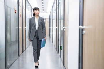 Workplace white-collar worker holding folder in office corridor