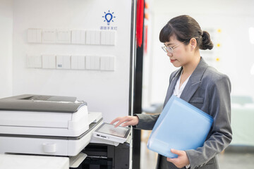 Office worker copying documents next to photocopier