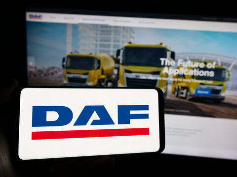 Stuttgart, Germany - 03-17-2024: Person holding mobile phone with logo of Dutch truck manufacturing company DAF Trucks NV in front of business web page. Focus on phone display.