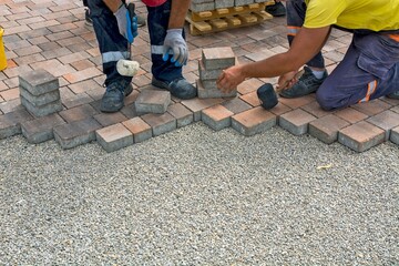 Construction workers collaborating together to construct a brick wall