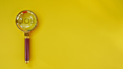 A magnifying glass with the word JOB. Minimalist background of job vacancy concept. Searching job.