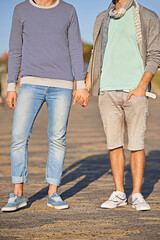 Holding hands, couple and clothes for fashion on road, location and city of Cape Town for love. Gay, person and partner with pride for relationship on date, sunshine and summer to relax and aesthetic