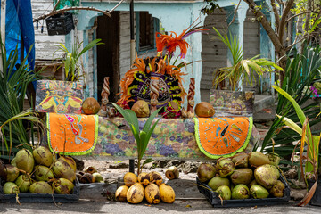 Piles of coconuts in front of an old building