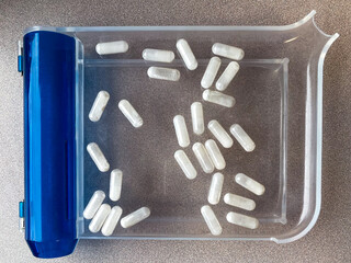 white capsules on pill counting tray