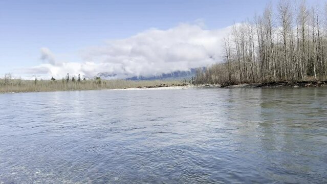 Sauk river in Washington state cascade mountains during early spring season with clear water and rolling clouds