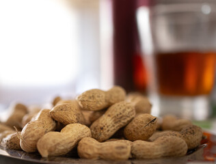 Close-up photo of a handful of peanuts with shells on a table prepared for a refreshing aperitif