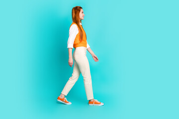 Full length photo of gorgeous lovely girl wear stylish outfit going looking empty space isolated on aquamarine color background