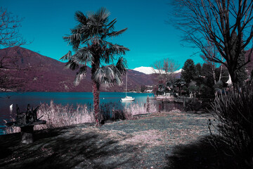 Moored sailboat, blue lake and snowed mountains. (Lake Orta - Italy).