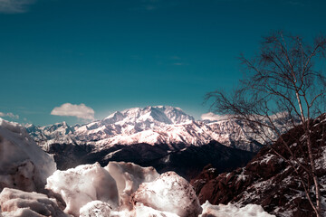 Monte rosa mountain, red rocks and snow. Suggestive view of Monte Rosa massif (the second highest mountain in the Alps) from Mottarone mountain. Piedmont - Italy.