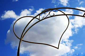 Forged heart against a cloudy sky