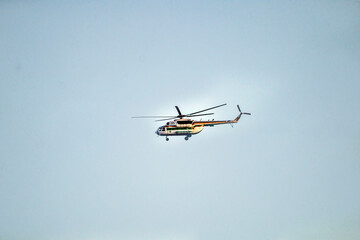 A gray helicopter flies in a clear sky