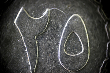 Metal texture of engraved symbols on an Arabic coin in macro	
