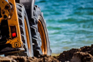 Large tractor wheels against the background of the sea