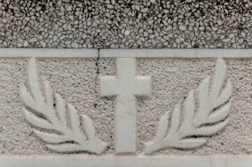 Detail of a tombstone in a cemetery. Cross and branches.