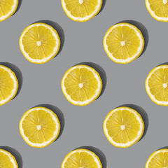 Uniform pattern of lemon slices with shadow on a gray background. Flat layout