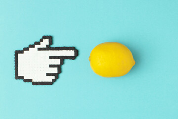 Creative food concept lemon and hand finger cursor on blue background. Flat lay.