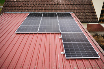 Solar panels are laid on the tin roof of a private house