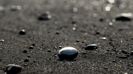 Volcanic black rocks and sand on the black sand beach in Reynisfjara in Iceland on March 2024