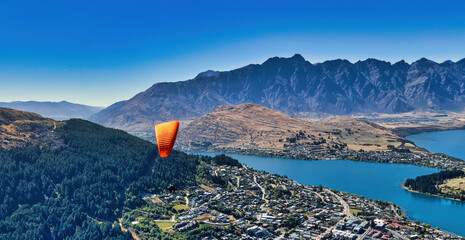 Paragliding over Queenstown New Zealand, majestic snowy mountains background, Sparkling Lake...