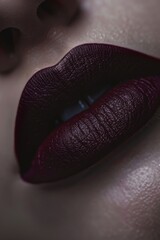 A detailed close-up of lips with a rich burgundy matte finish, highlighting texture and color.