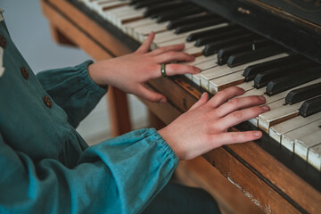 Close up of young girls hands, playing piano. vintage tone filter effected