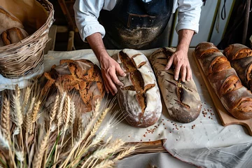 Cercles muraux Boulangerie baker arranging rye bread beside fresh rye ears on a table