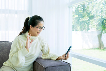 Woman spend time at home seated on sofa