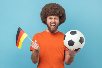 Portrait of crazy man with Afro hairstyle holding flag of germany and soccer black and white...