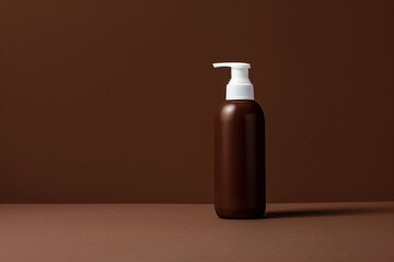 Sleek and modern skincare bottle with a pure, white design against a rich chocolate brown isolated...