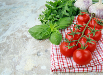 Cherry tomatoes and fresh basil on a wooden table
