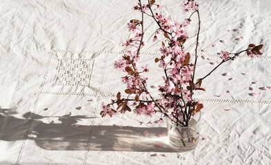 Spring still life with flowering branches on a natural linen tablecloth. Eco linen, sustainable development. Romantic still life  
