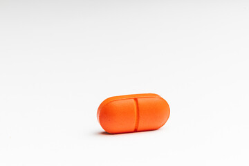 Close up picture of Coloured capsules , pills and tablets against a white background.