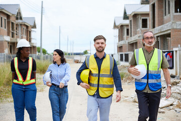 group of workers or architects walking and talking about work at construction site