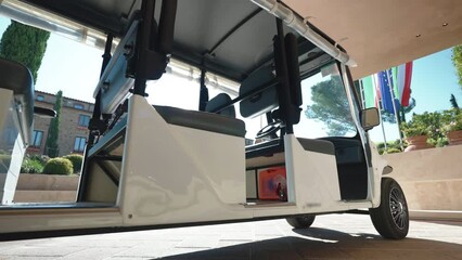 Golf cart on parking lot near the luxury hotel, tourists and guests delivery service of European hotels, electrical transport for people delivery