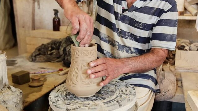 Man at pottery workshop. Unrecognized man producing pitcher from clay at pottery shop in Bahrain