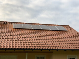 Solar panels on the roof of a house with red tiles