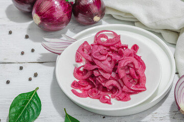 Jar with tasty pickled onions on black table. Cutlery, served meal ready to eat, trendy stand