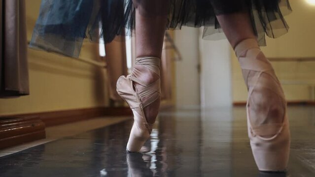 Beautiful legs of a ballerina in pointe shoes dancing on the floor