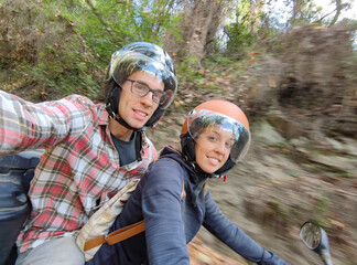 Young couple on a mountain route on an all-terrain quad. It's a selfie and she drives