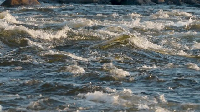 Close-up of powerful and turbulent river waves with choppy and wild movement in the freshwater stream showcasing the dynamic energy and fluidity of natures powerful current and rapid flow in Estonia