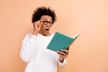 Photo of excited surprised man wear trendy white clothes look book page open mouth interesting plot isolated on beige color background