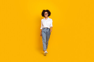 Full length body size view of attractive smart cheerful girl assistant going isolated over bright yellow color background - obrazy, fototapety, plakaty